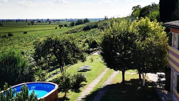 A residential area with a swimming pool, a garden with a paved path, and a view of the countryside. - Agriturismo El Crear (San Pietro in Cariano)