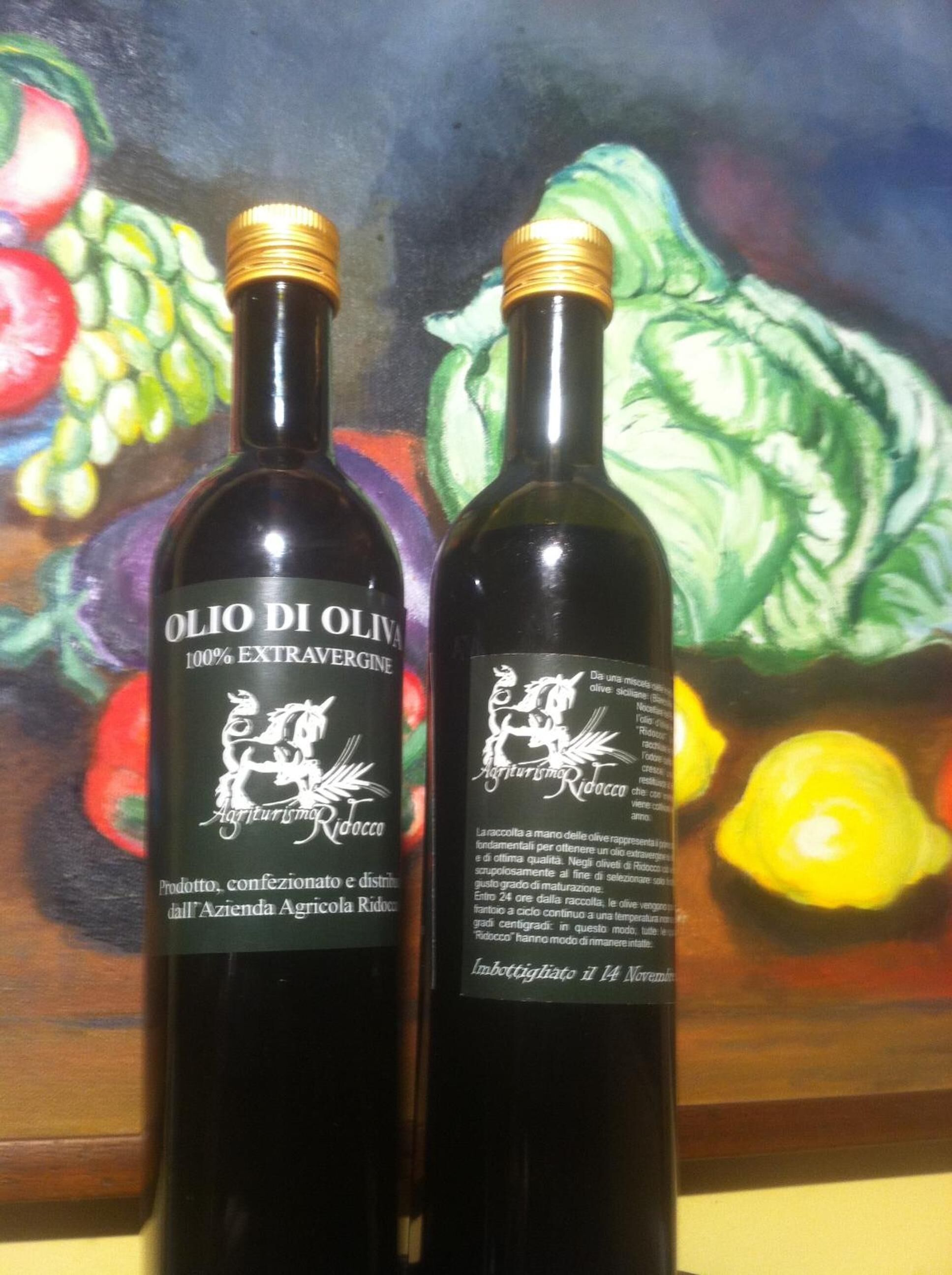 Two bottles of Olio Di Olio wine with labels indicating they are 100% extra virgin olive oil.