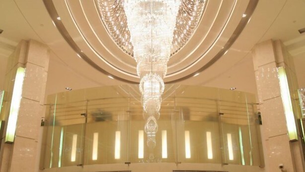 A grand interior with a large, ornate chandelier hanging from the ceiling. - Jialuan International Hotel (Taizhou)