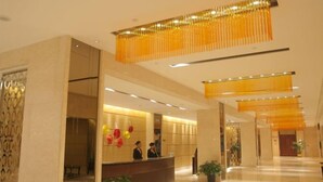A hotel lobby with a reception desk, a waiting area, and a hallway leading to other rooms. - Jialuan International Hotel (Taizhou)