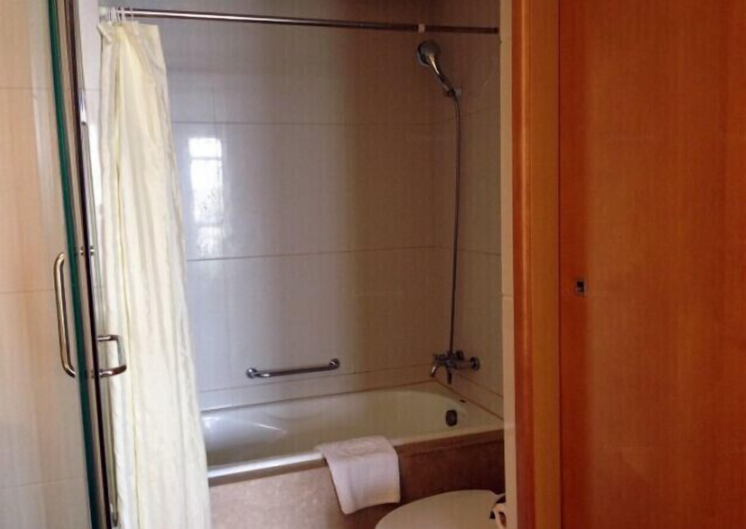Une salle de bain avec une douche, une baignoire et des toilettes.