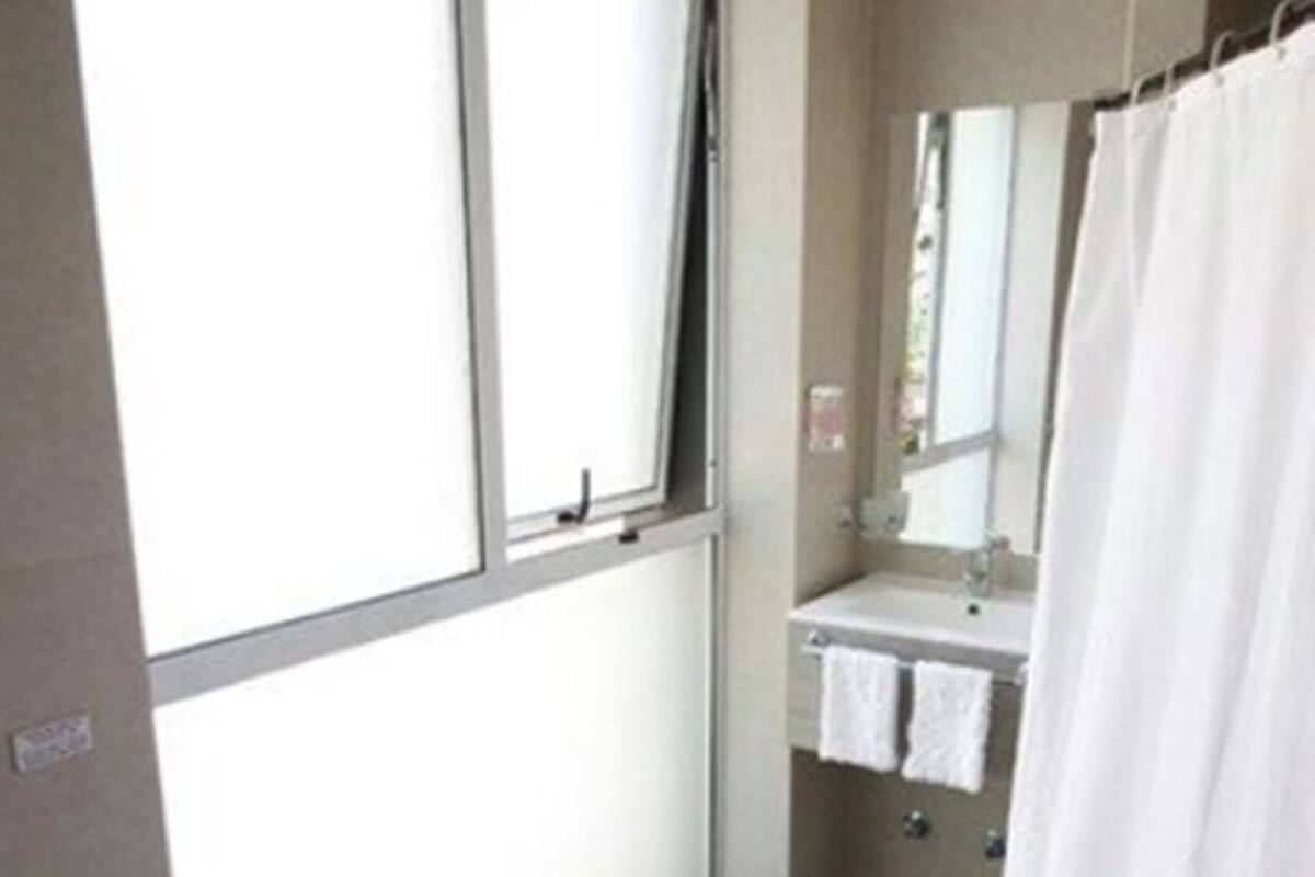 Un baño con inodoro, lavamanos y cortina de ducha.