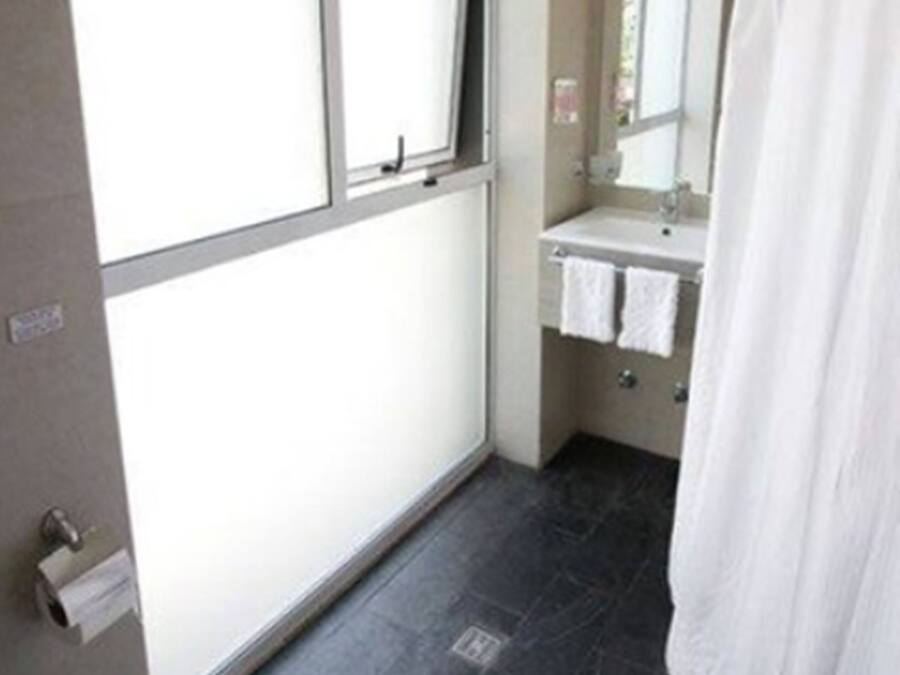 Un baño con inodoro, lavamanos y espejo.