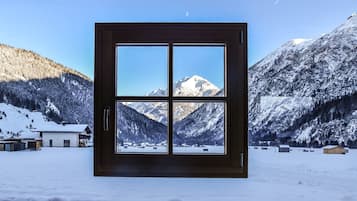 A window with a four-pane view of a snowy mountain landscape.