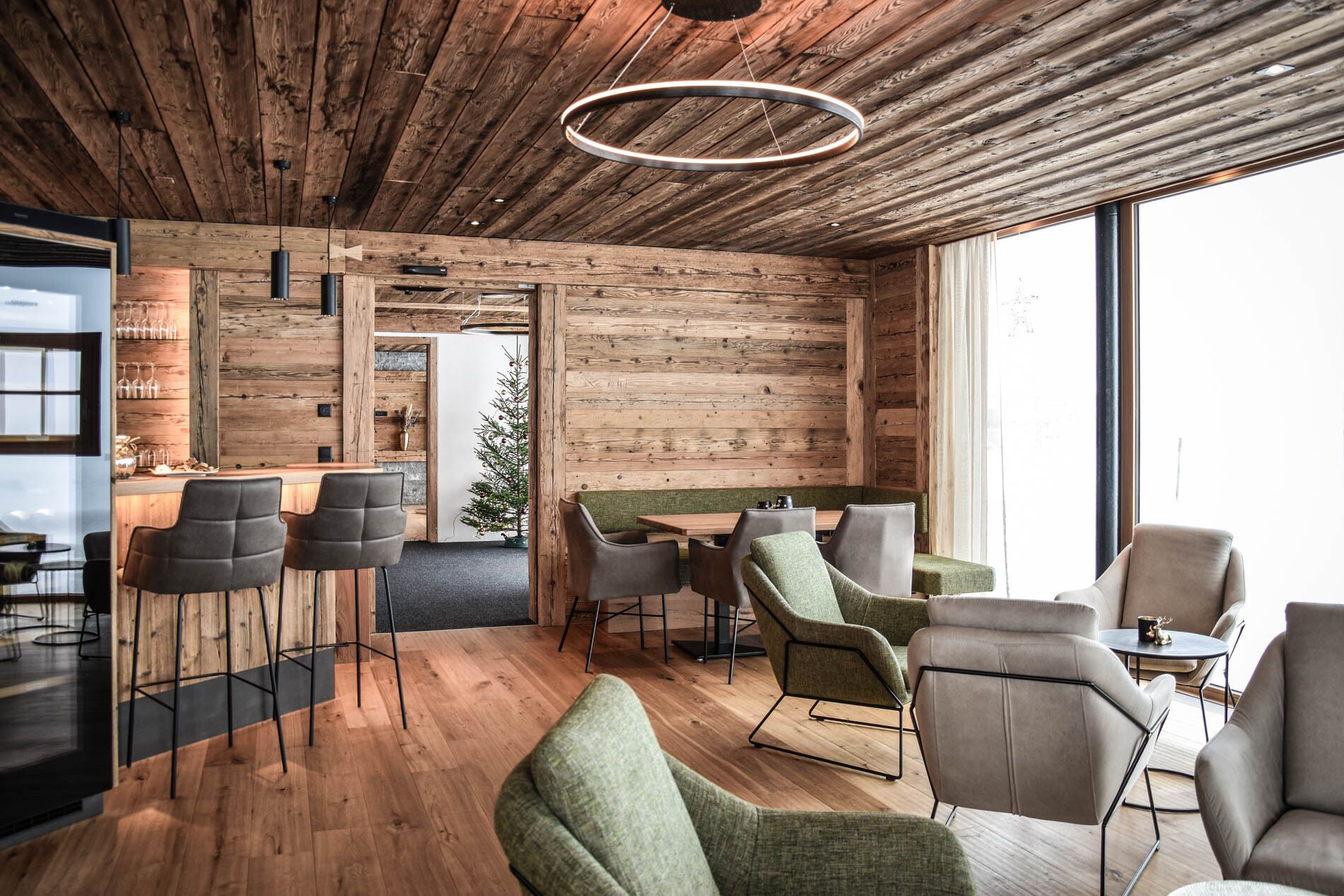 Un interior moderno con paredes de madera, una zona de bar y diferentes disposiciones de asientos.