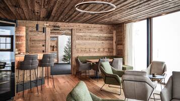 Un interior moderno con paredes de madera, una zona de bar y diferentes disposiciones de asientos.