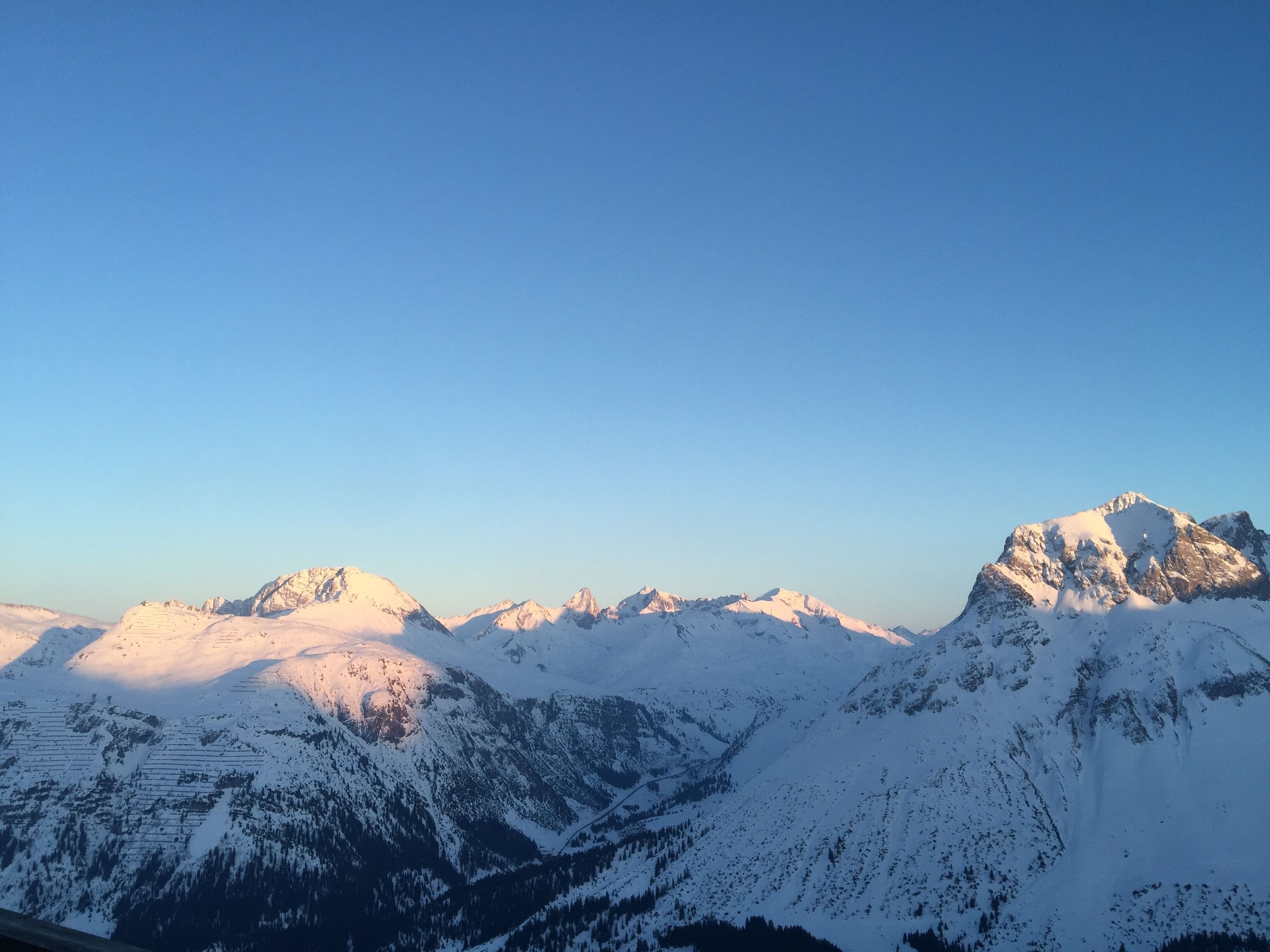 Vista panorámica de montañas nevadas bajo un cielo despejado.