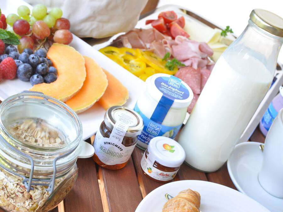 Uma mesa de café da manhã com diversos alimentos e bebidas.
