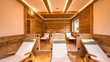 Relax in a serene spa room with six reclining chairs and a wooden ceiling with exposed beams.