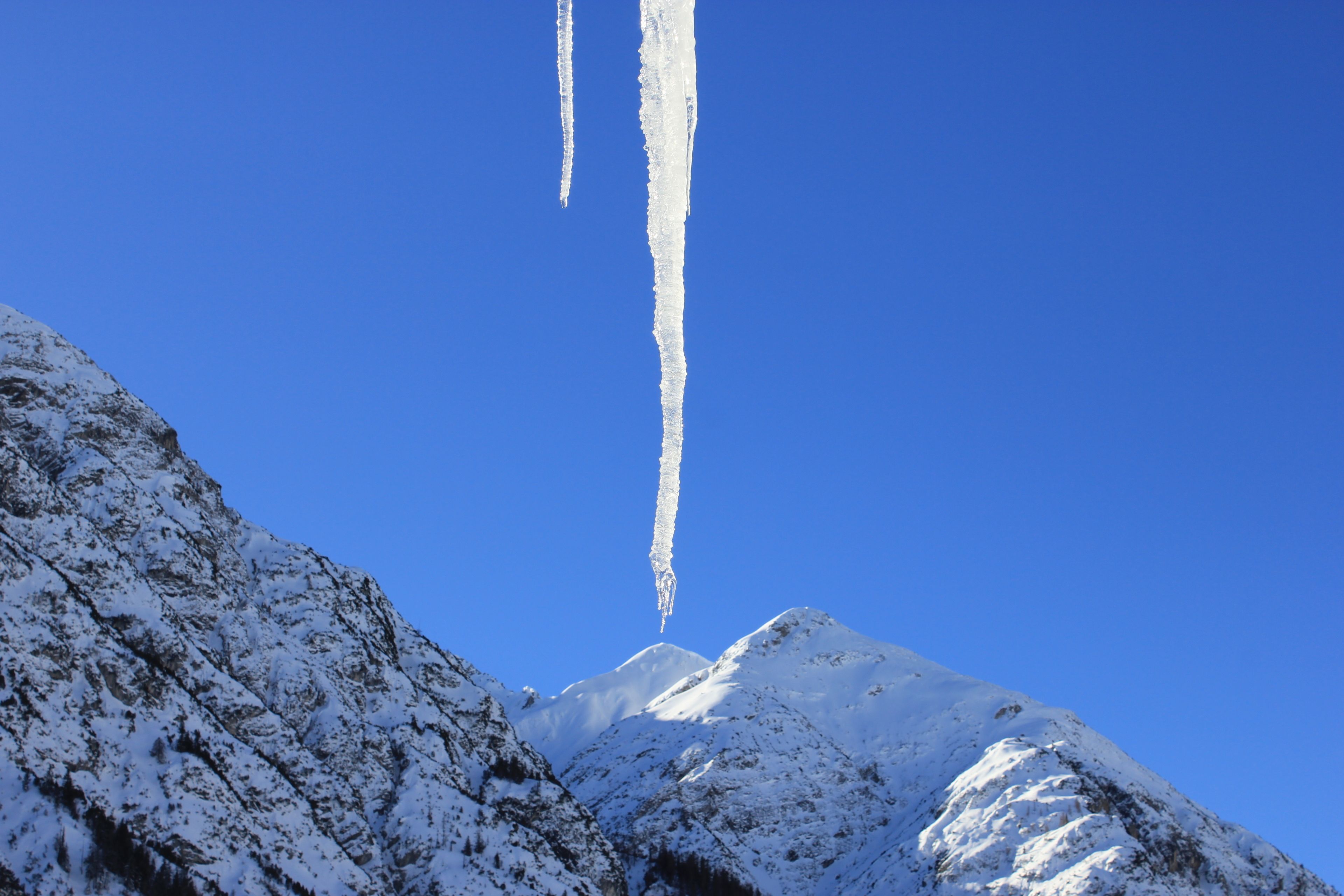 A snow-covered mountain peak with a clear blue sky.