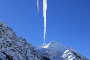 Un pico nevado de montaña bajo un cielo azul despejado.