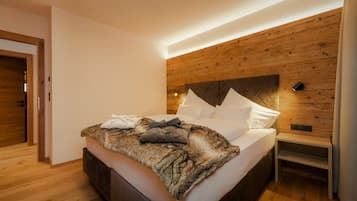Ein modernes Schlafzimmer mit einem Holzkopfteil, einem Bett mit weißen Leinen und einer flauschigen Decke.