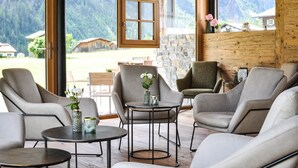 A modern lounge with comfortable seating and a large window offering a mountain view.