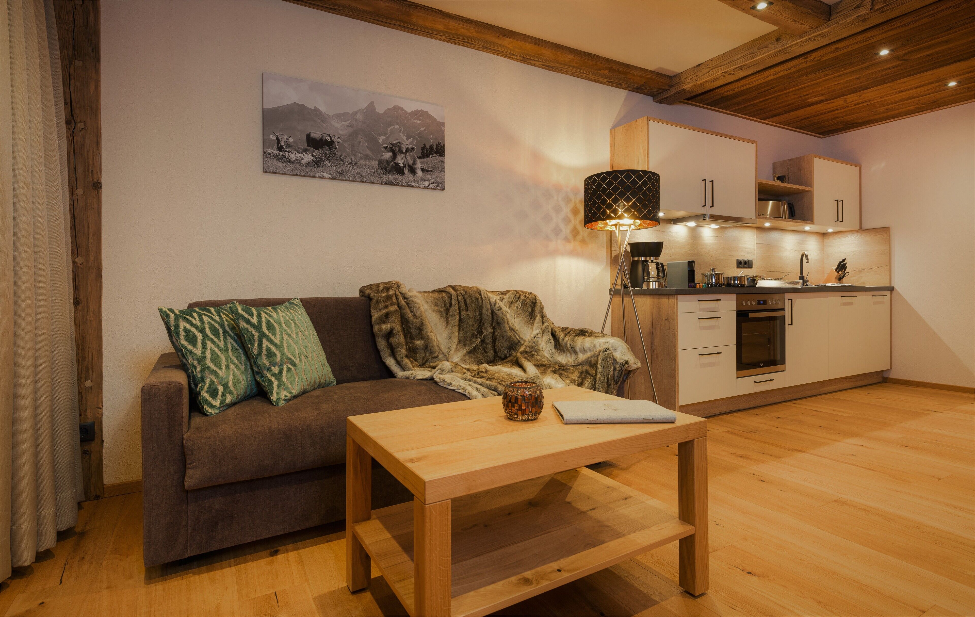 A cozy living area with a sofa, a coffee table, and a kitchen in the background.
