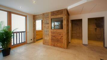 Una habitación espaciosa con un gran ventanal, paneles de madera y una planta en maceta.
