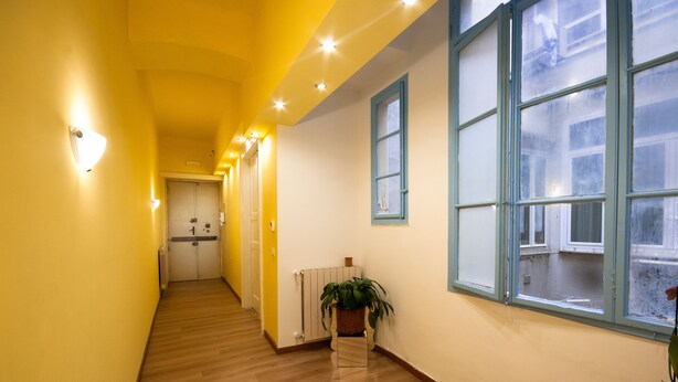 A hallway with wooden flooring, yellow walls, and a potted plant. - B&B Dream Center (Trieste)