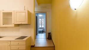 A narrow hallway with a kitchen on one side and a bedroom on the other. - B&B Dream Center (Trieste)