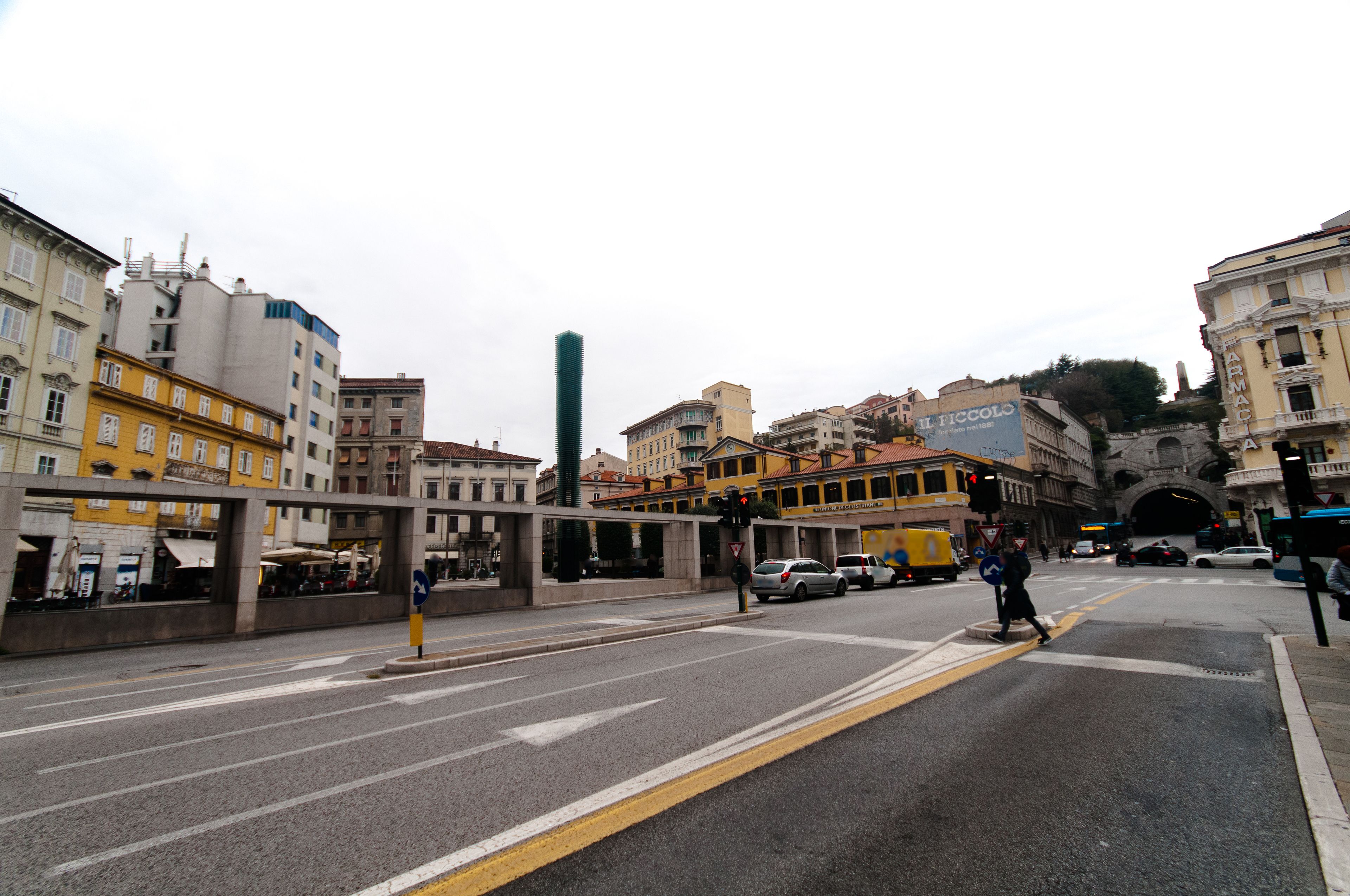 A street intersection with buildings, a pedestrian crossing, and a traffic light.