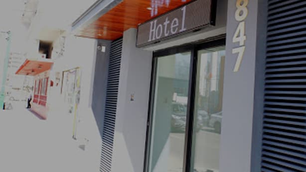Exterior de un hotel con un letrero que dice "Hotel 847" y una entrada visible.