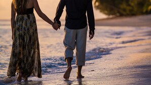 A couple walking hand in hand on a beach at sunset. - Kakaia Retreat (Rarotonga)
