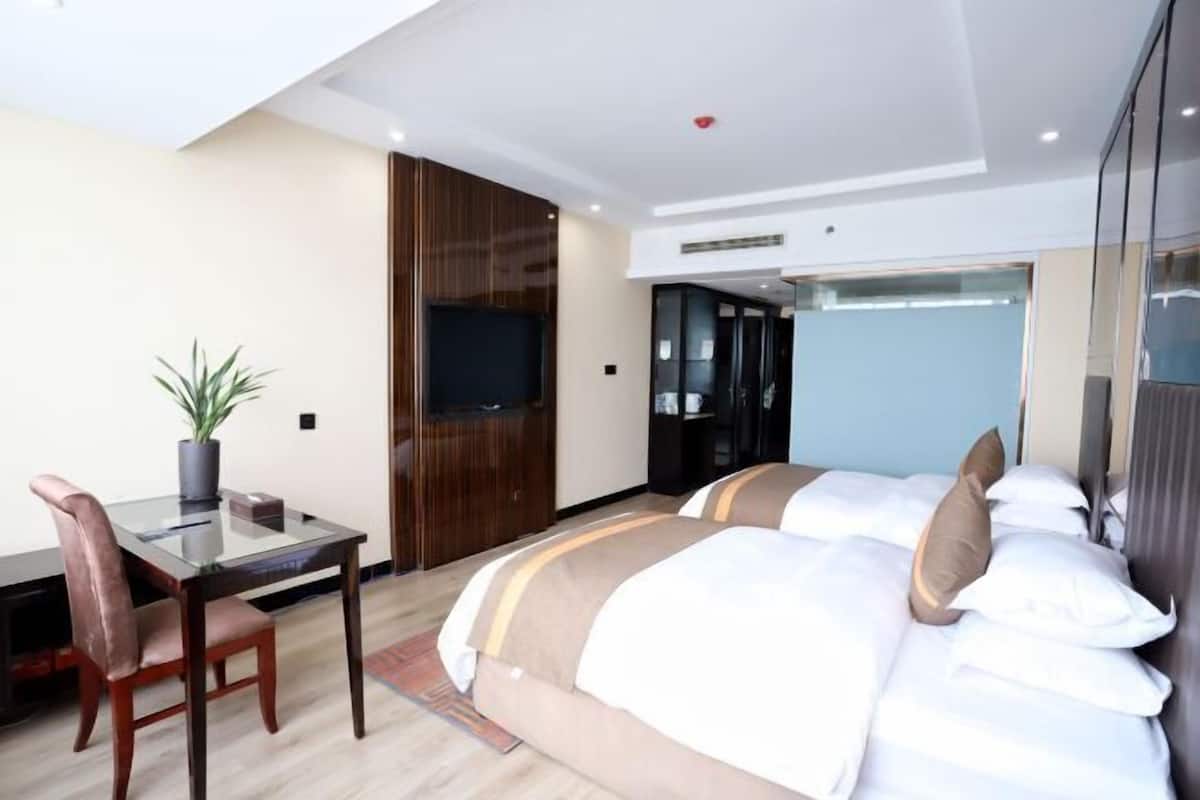A hotel room with a bed, a desk, and a television.