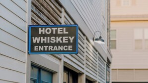 Ein Schild mit der Aufschrift 'HOTEL WHISKEY ENTRANCE' an der Gebäudefassade.
