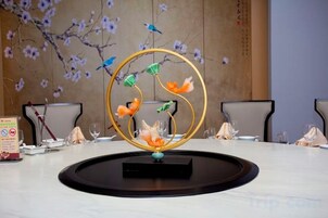 Una mesa de conferencias con un centro de mesa decorativo, sillas y un letrero con texto.