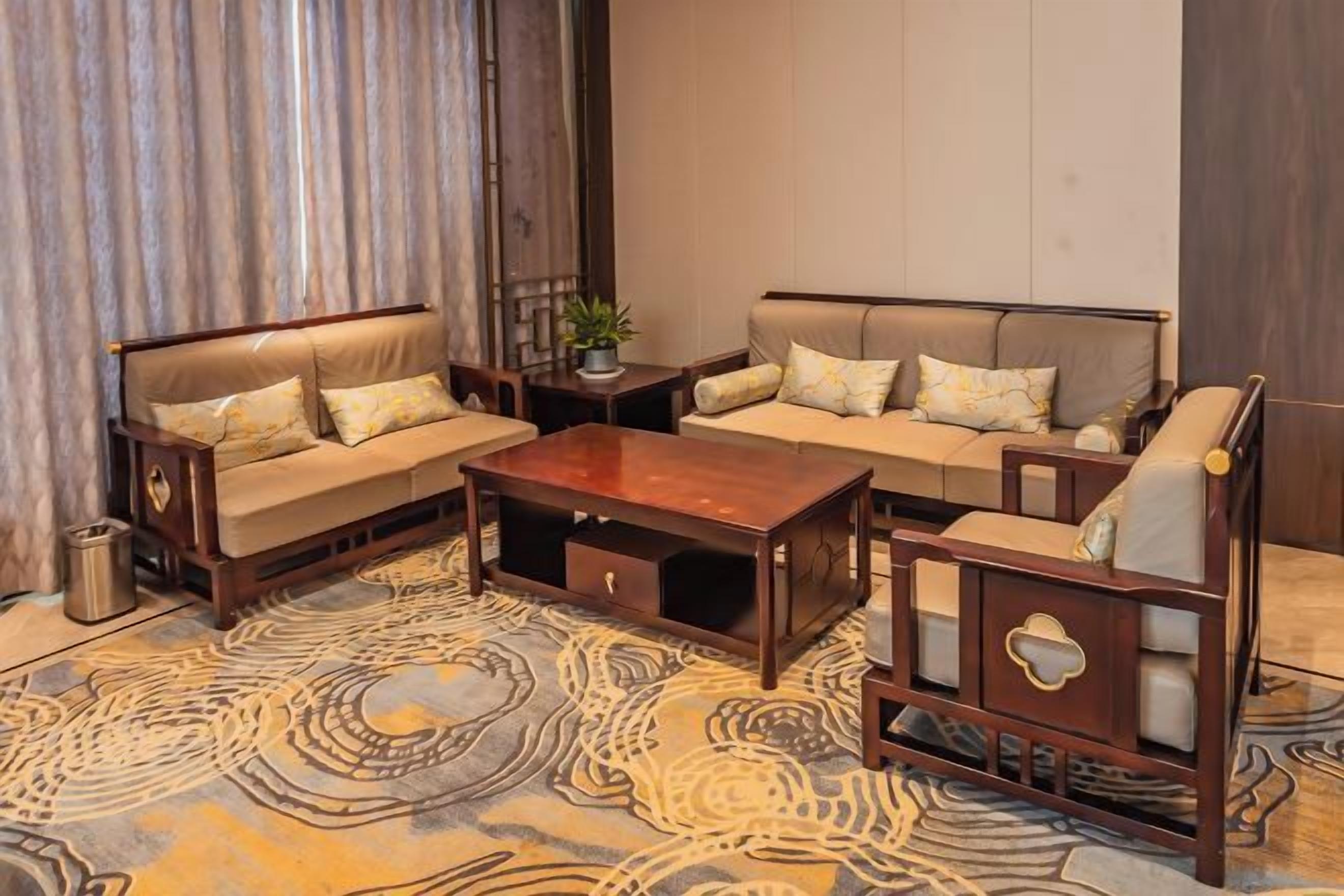 Uma sala de estar com sofá, mesa de centro e tapete estampado.