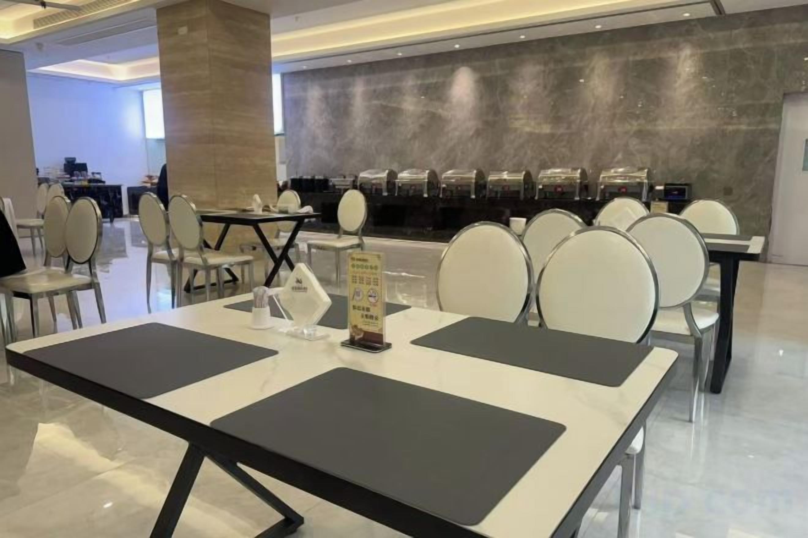 A hotel dining area with tables and chairs, a counter with a menu, and a modern interior design.