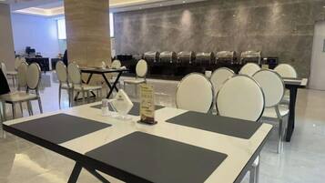 A hotel dining area with tables and chairs, a counter with a menu, and a modern interior design.