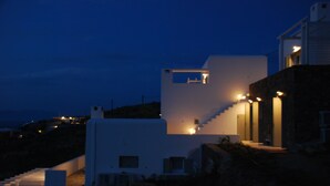 Un edificio moderno con una escalera que lleva a un segundo piso, rodeado por un paisaje montañoso.