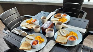 A dining table with plates of food, cups, and a box of tissues. - Hotel Balcones de la 70 (Medellín)