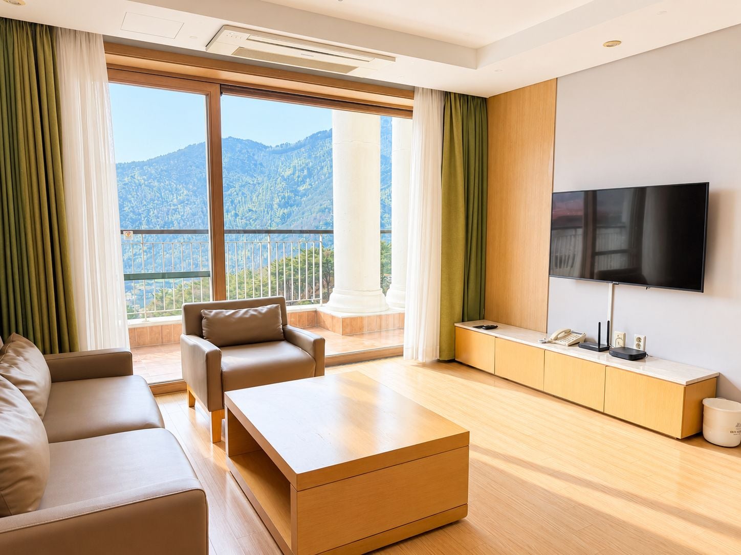A modern living room with a sofa, coffee table, and a TV mounted on the wall.