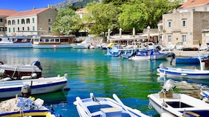 A marina with various boats docked, surrounded by buildings and trees. - Villa Giardino Heritage Boutique Hotel Bol (Bol)