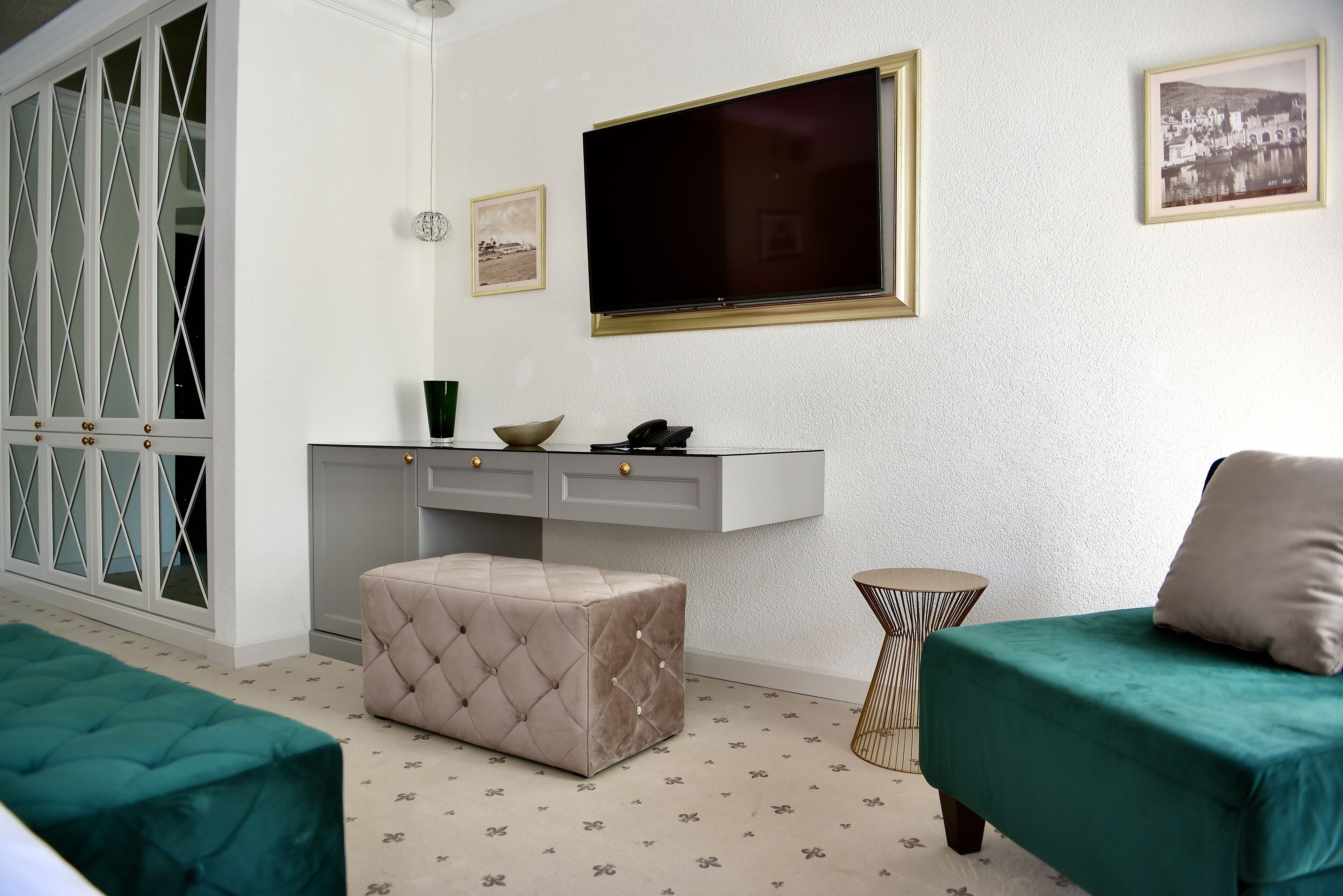 Ein kleines Zimmer mit einem Bett, einem kleinen Schreibtisch, einem Fernseher und einem Kleiderschrank.