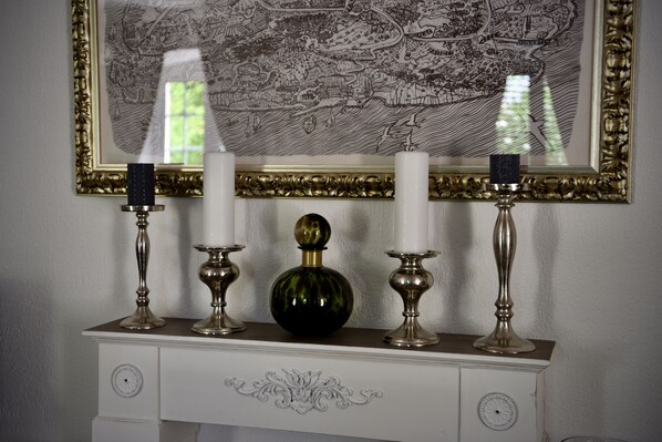 A white dresser with a decorative mirror above it, featuring a black and gold frame.