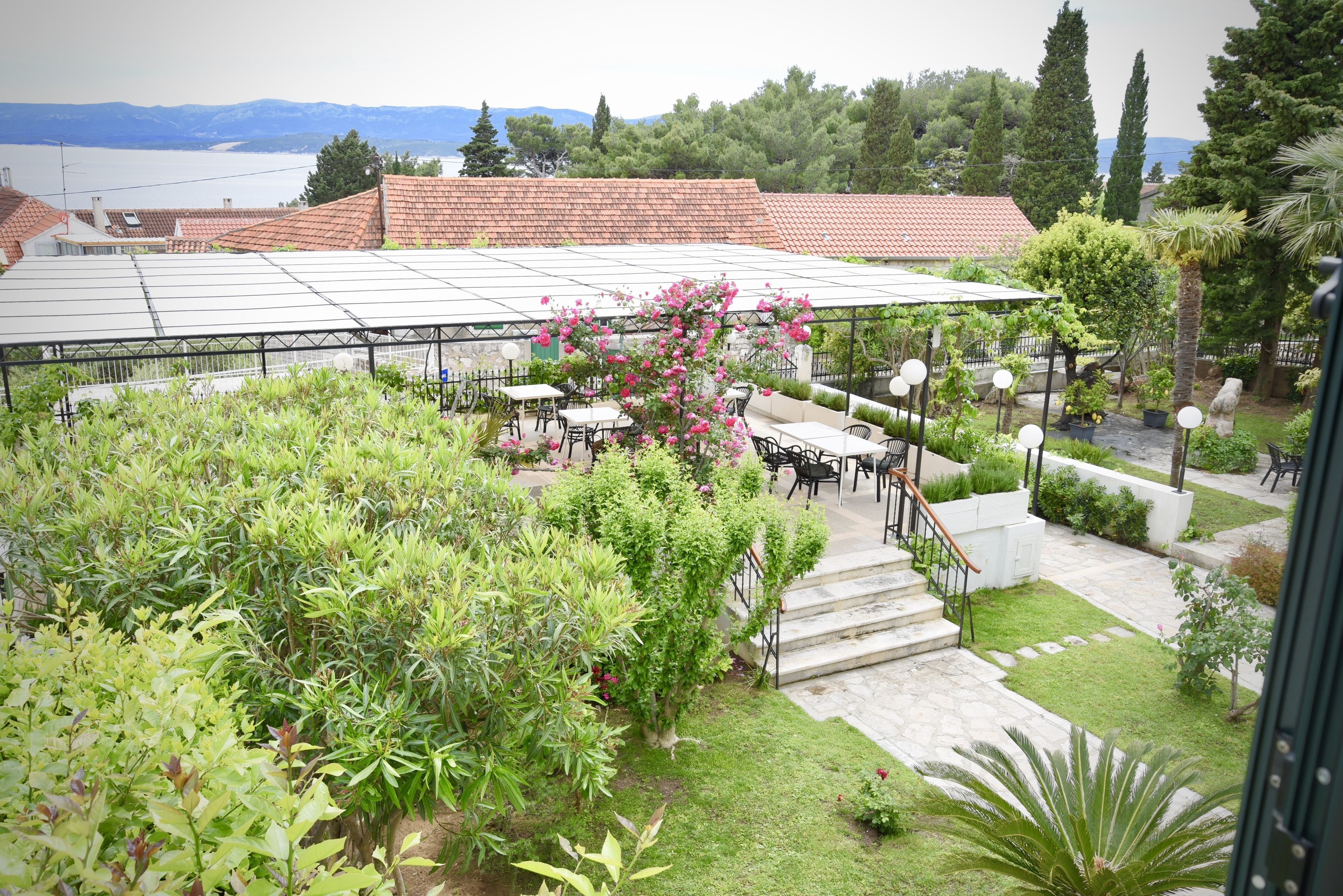Un jardin sur le toit, doté d’un espace extérieur aménagé avec des sièges, d’une pergola et offrant une vue sur le paysage environnant.