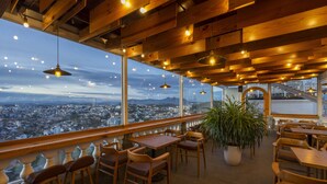 A restaurant with wooden furniture, large windows, and hanging lights. - New Life Dalat Hotel (Xuan Huong - Da Lat)