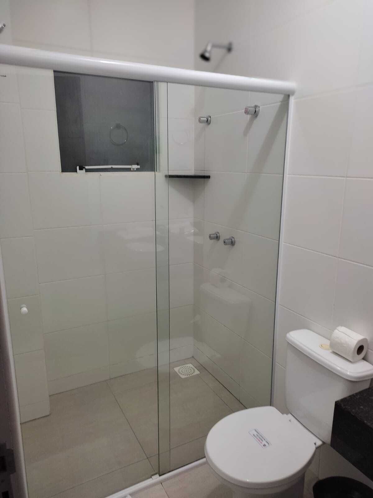 A modern bathroom with a glass shower enclosure, a toilet, and a sink.