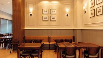 Un restaurante con mesas y cabinas de madera, cuadros en la pared e iluminación empotrada.