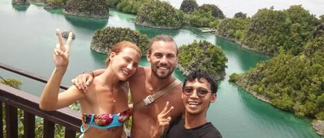 Uma varanda com vista para uma paisagem deslumbrante de um rio, com vegetação exuberante e pequenas ilhas.