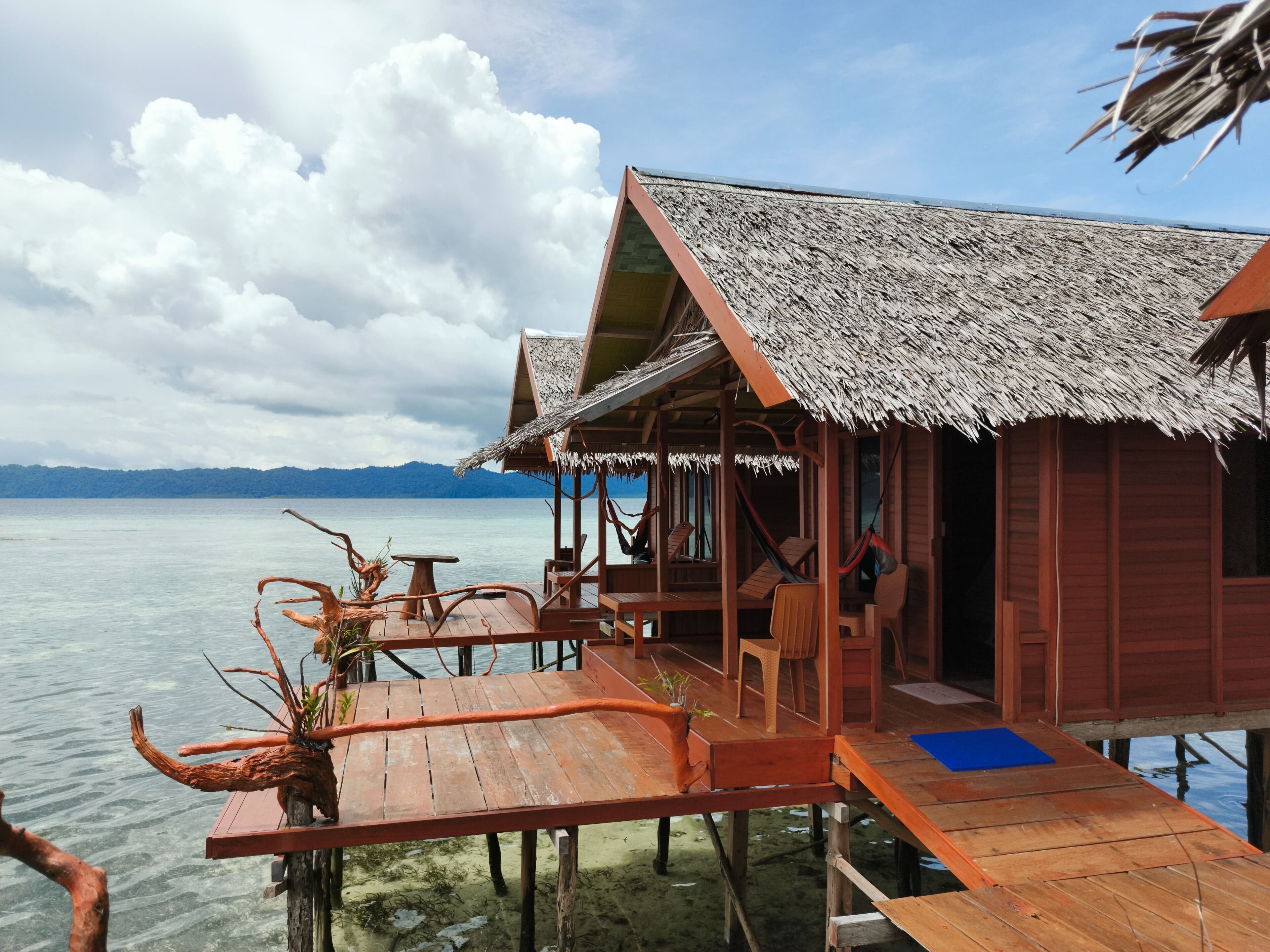 A wooden structure with a thatched roof overlooking a body of water.