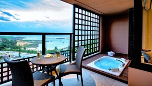 A balcony with a view of the sea, a hot tub, and wicker furniture. - Hotel Shigira Mirage (Miyakojima)