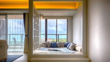 Une pièce moderne dotée d’une banquette intégrée près de la fenêtre, d’un canapé blanc et offrant une vue sur la mer.