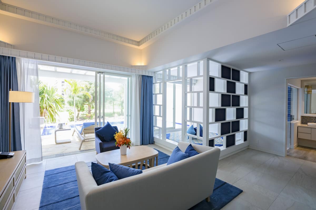 A modern living room with a sofa, a coffee table, and a bookshelf.