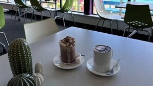 Un coin repas avec une table dressée pour deux personnes, comprenant un dessert et une boisson.