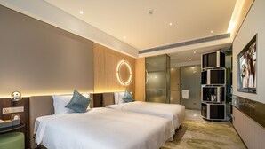A hotel room with two beds, a vanity with a mirror, a small seating area, and a kitchenette. - Anban Hotel (Shenzhen)