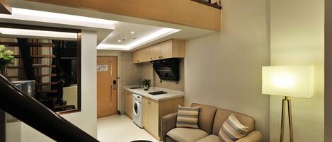 Un apartamento moderno con sala de estar, kitchenette y balcón.