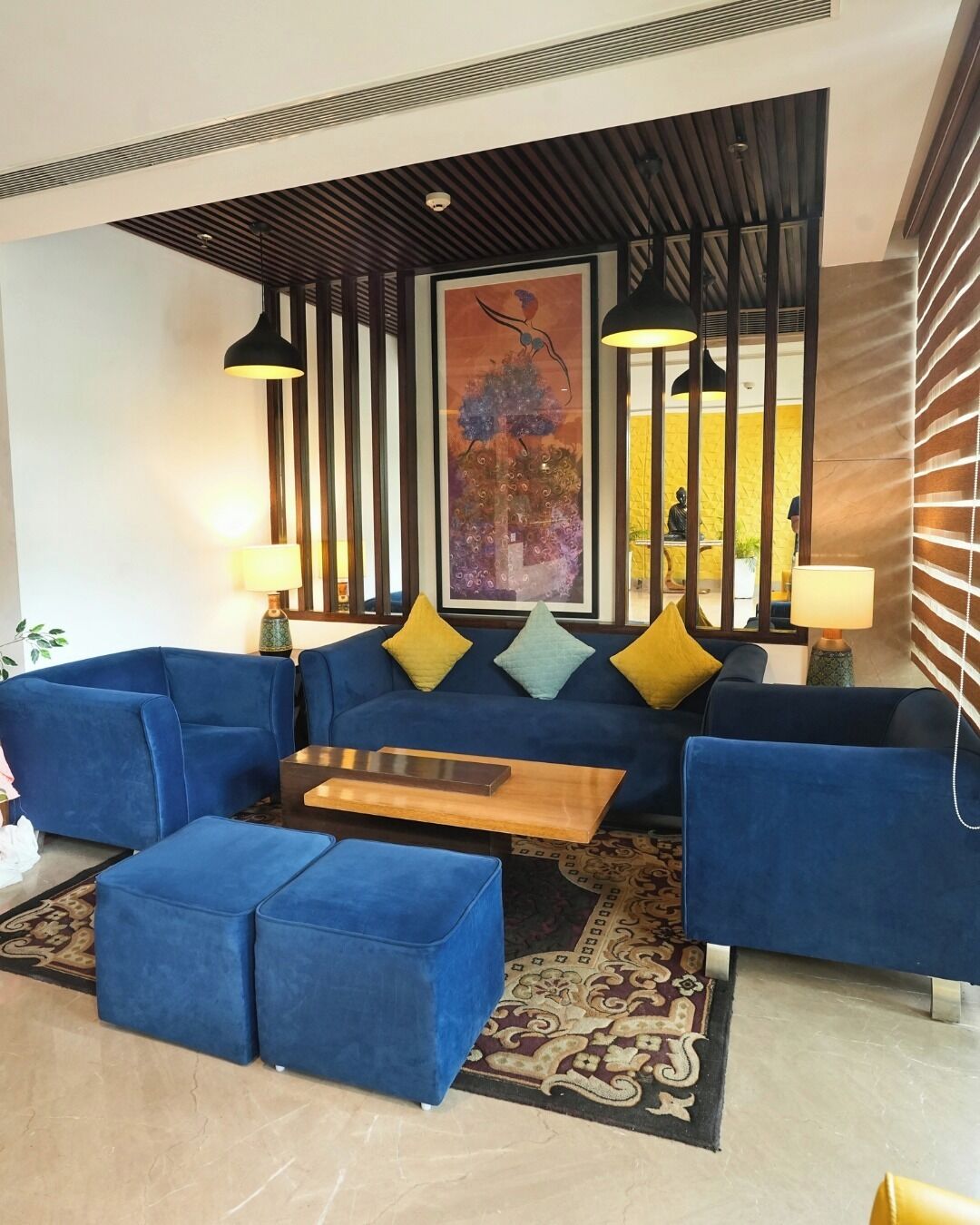 A modern living room with a blue sofa set, a wooden coffee table, and decorative pillows.