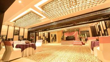 Un amplio salón de banquetes con asientos escalonados, suelo estampado y techo decorativo.